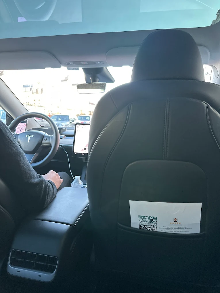 Vue depuis la banquette arrière de la Tesla Model Y, le chauffeur au volant